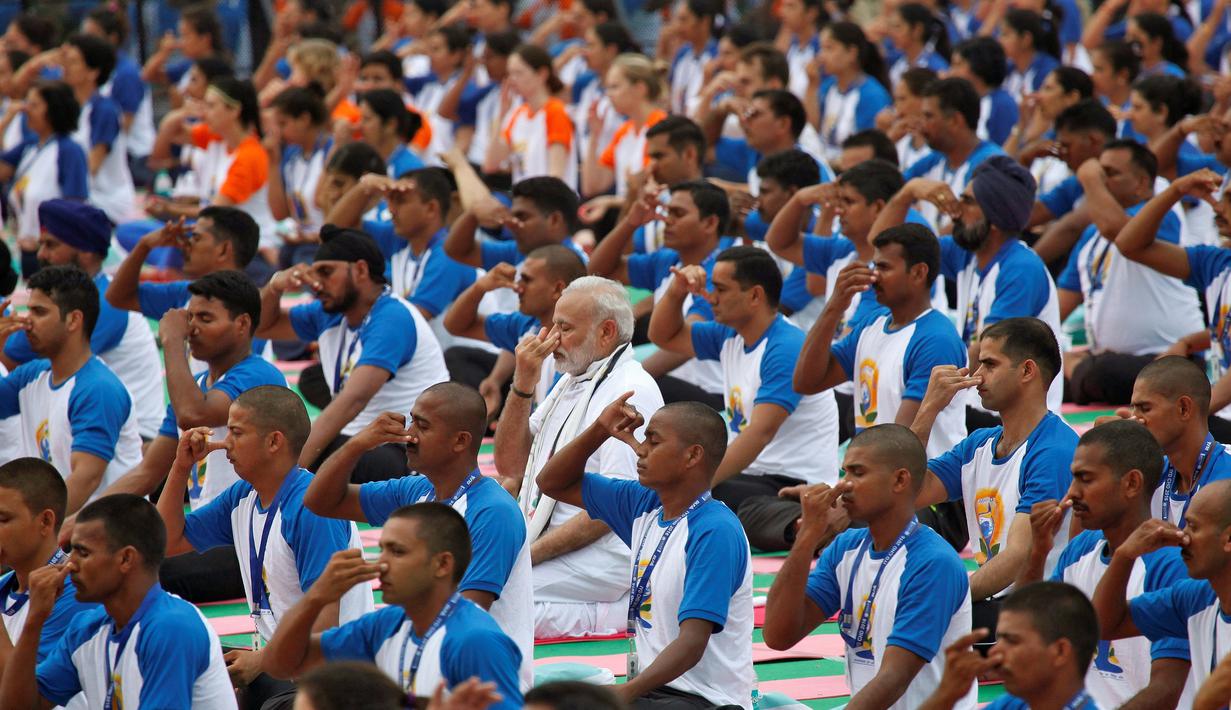 Perdana Menteri India Narendra Modi (tengah) melakukan gerakan Yoga bersama warga lainnya di Chandigarh , India , (21/6). Sejumlah negara di dunia sedang merayakan Hari Yoga Dunia yang jatuh pada tanggal 21 Juni. (REUTERS / Ajay Verma)