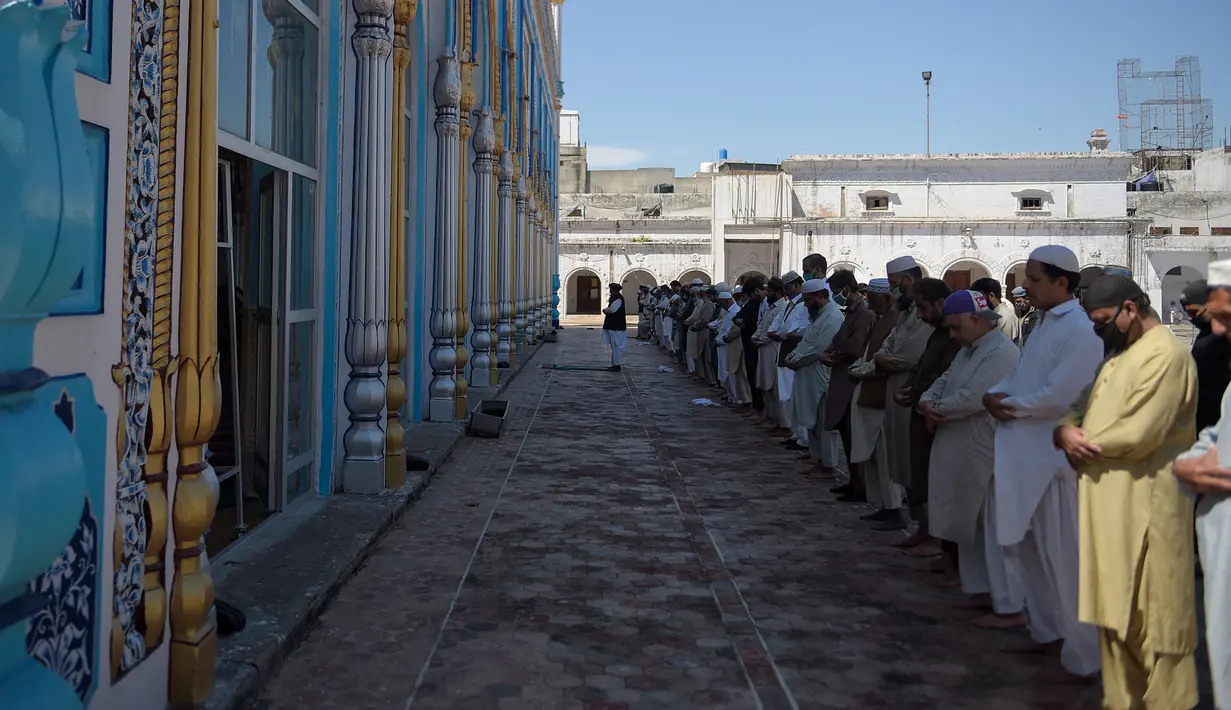 Umat Muslim melaksanakan Salat di sebuah masjid sambil menjaga jarak sosial selama penguncian nasional yang diberlakukan pemerintah sebagai tindakan pencegahan terhadap coronavirus COVID-19, di Rawalpindi, Pakistan (19/4/2020). (AFP/Farooq Naeem)