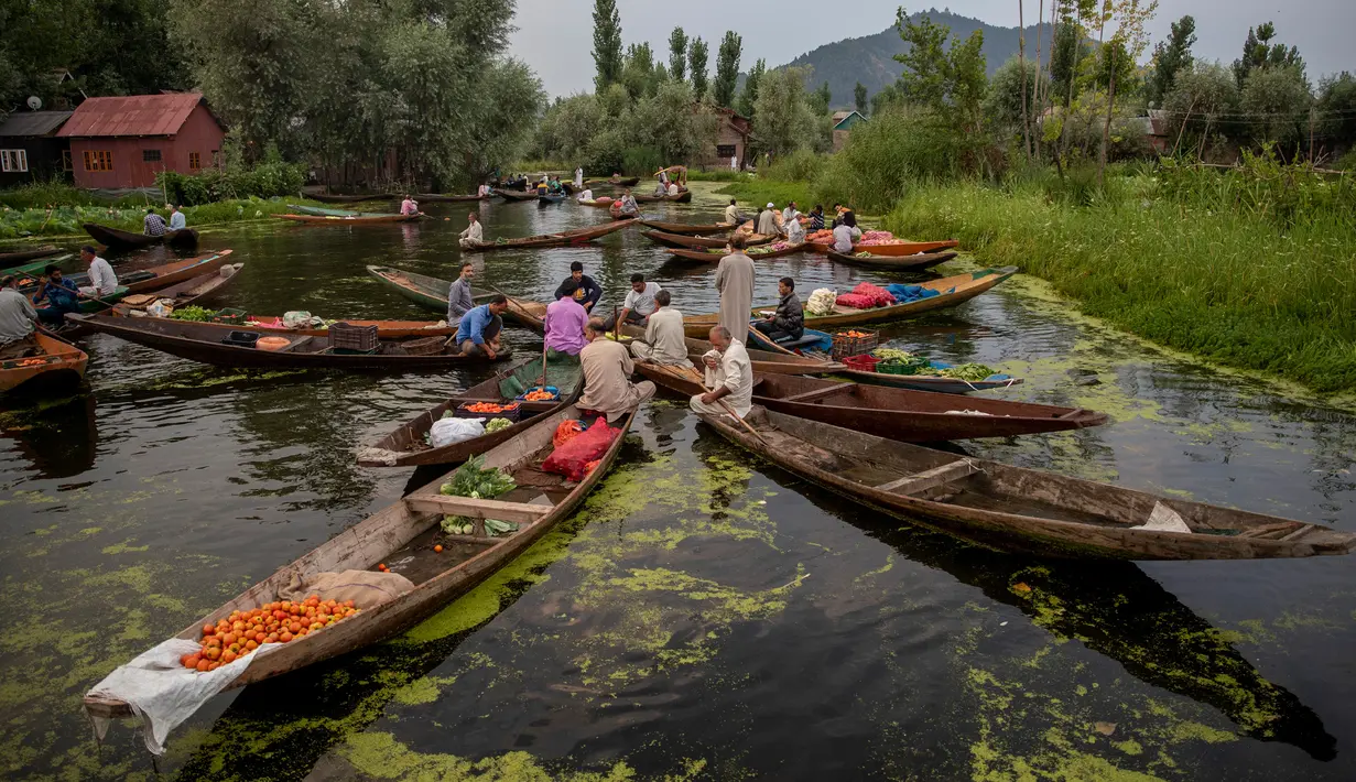 Para pria Kashmir menjual produk mereka di pasar sayur terapung di Danau Dal di Srinagar, Kashmir yang dikuasai India pada 26 Juli 2020. Sayuran yang diperdagangkan di pasar terapung ini disuplai ke Srinagar dan banyak kota di lembah Kashmir. (AP Photo/Dar Yasin)