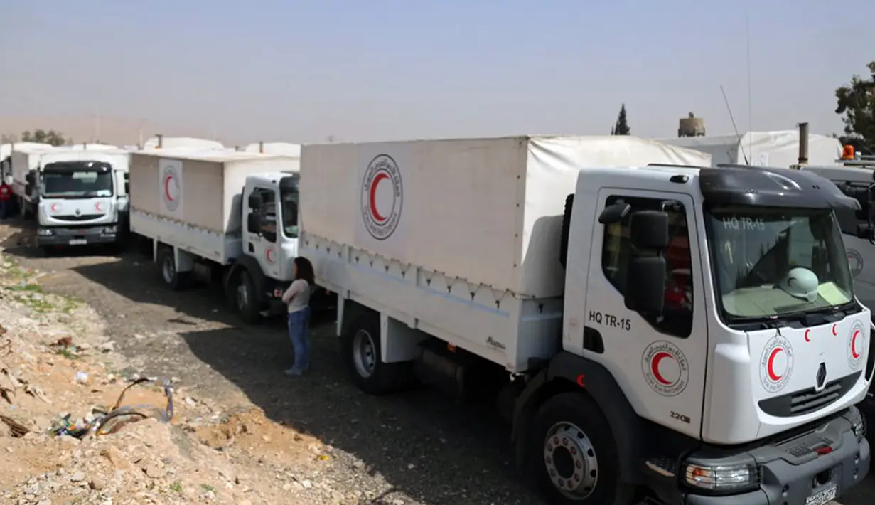 Konvoi truk bantuan Bulan Sabit Merah Suriah tiba di Douma, Ghouta Timur, Damaskus, Suriah, Senin (5/3). Bantuan terdiri dari makanan dan obat-obatan. (Syrian Red Crescent via AP)