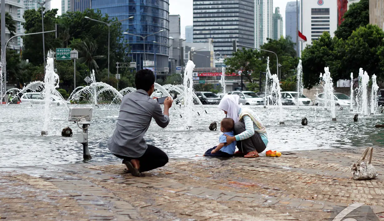 Sejumlah keluarga berfoto bersama di Bundaran Hotel Indonesia (HI), Jakarta, Kamis (1/1/2015). (Liputan6.com/Faizal Fanani)