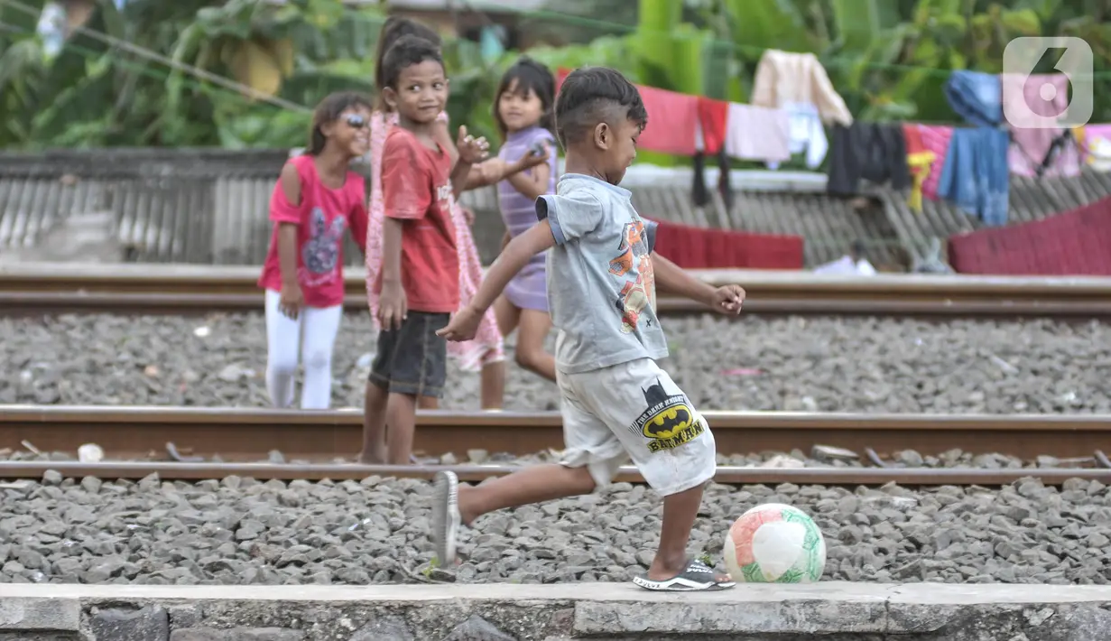 Anak-anak saat bermain di dekat rel kereta api di kawasan Bahari Ujung, Tanjung Priok, Jakarta Utara, Selasa (24/5/2022). Minimnya fasilitas dan ruang terbuka hijau di kawasan tersebut menyebabkan anak-anak setempat memilih bermain di sekitar perlintasan kereta api yang dapat membahayakan keselamatan mereka. (merdeka.com/Iqbal S Nugroho)