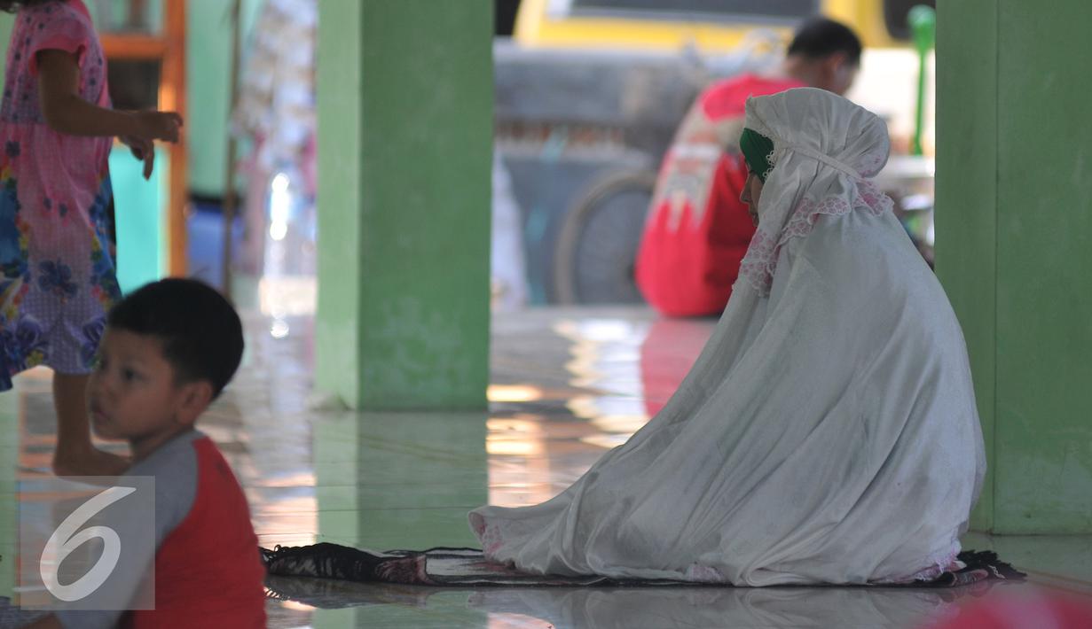 Pemudik melakukan ibadah saat berhenti di sebuah mesjid di kawasan Arjawinangun, Cirebon, Jawa Barat, Rabu (15/7/2015). Banyak pemudik melakukan aktivitas seperti salat, mengaji, tidur dll di mesjid tersebut. (Liputan6.com/Herman Zakharia)