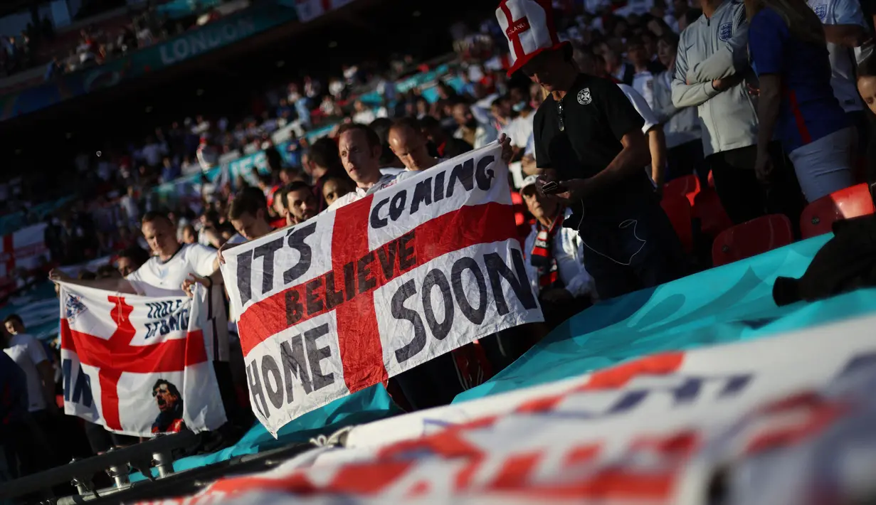 Fans Inggris mengibarkan bendera saat menyaksikan pertandingan semifinal bola Euro 2020 antara Inggris dan Denmark di Wembley Stadium, London, Kamis dinihari WIB (8/7/2021). Inggris melaju ke babak final Euro 2020 melawan Italia setelah mengalahkan Denmark dengan skor 2-1. (Carl Recine/POOL/AFP)