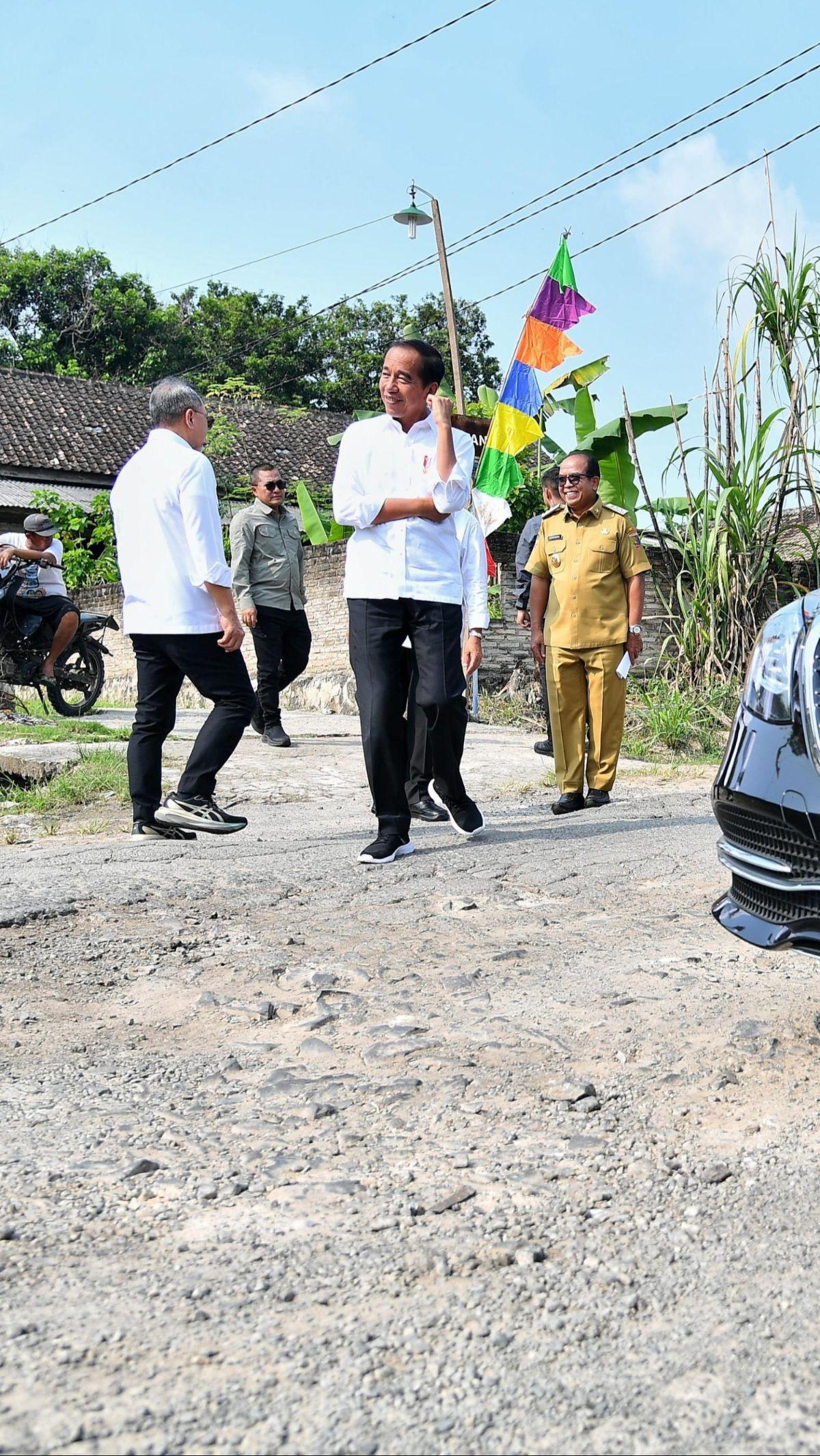 Jokowi kemudian turun dari mobil kepresidenan dan mengecek langsung jalan rusak yang dilewatinya.&nbsp;Foto: BPMI Setpres/Vico