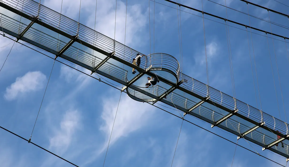 Foto yang diambil pada 4 Mei 2019 menunjukkan orang-orang mengunjungi jembatan berlantai kaca di Huaxi Adventure Park, Provinsi Jiangsu timur China. Jembatan kaca setinggi 518 meter ini menjadi tujuan wisata favorit di China. (Photo by STR / AFP)