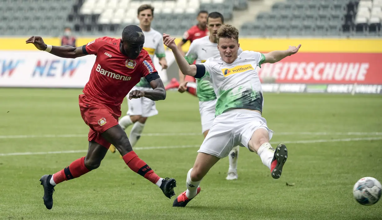 Pemain Bayer Leverkusen, Moussa Diaby, melepaskan tendangan ke gawang Borussia Moenchengladbach pada laga Bundesliga, Minggu (24/5/2020). Bayer Leverkusen menang 3-1 atas Borussia Moenchengladbach. (AFP/Ina Fassbender)