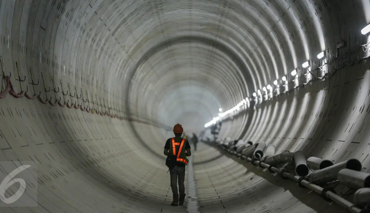 Seorang pekerja melintas di dalam terowongan mass rapid transit (MRT) yang masih dalam tahap penyelesaian di Jakarta (6/4). PT. MRT Jakarta mencatat progres pengerjaan telah mencapai 68,98 - 70 persen. (Liputan6.com/Faizal Fanani)