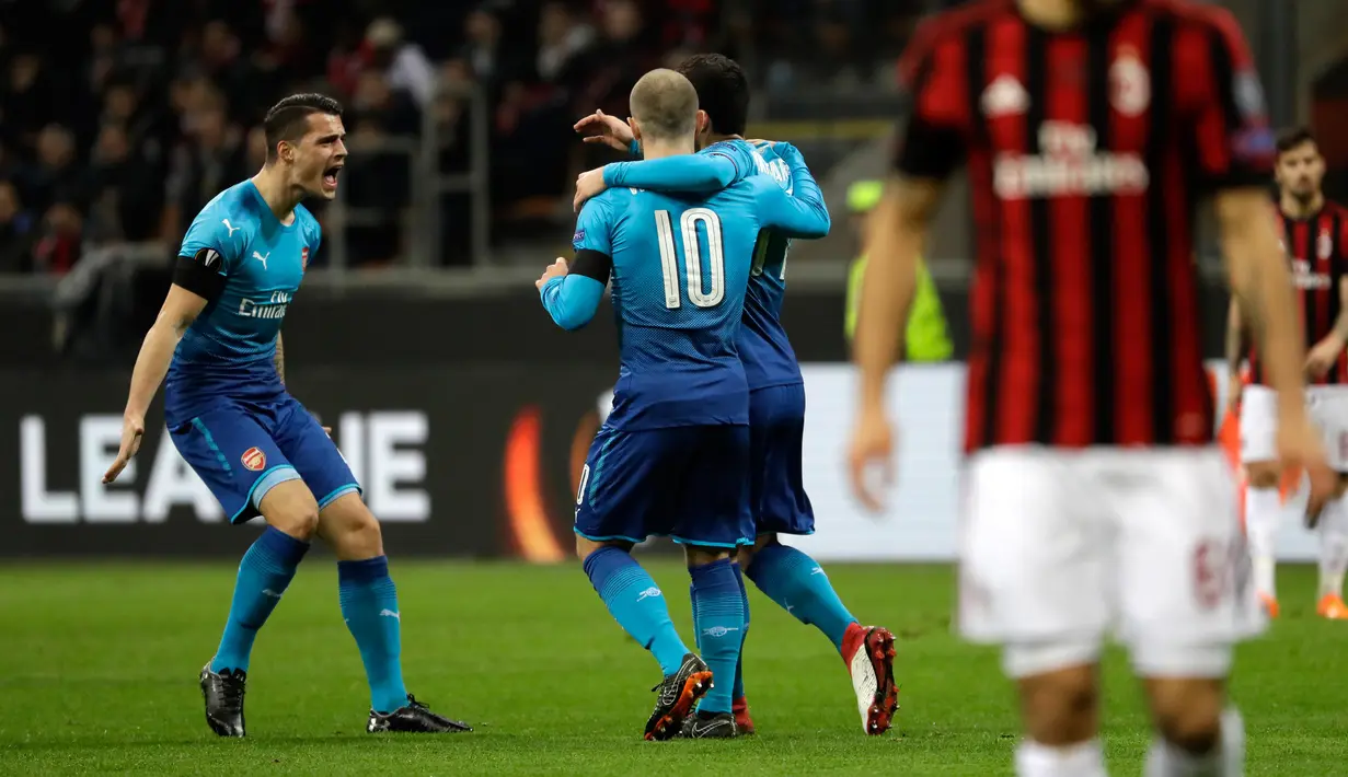 Pemain Arsenal Henrikh Mkhitaryan merayakan gol bersama rekannya saat melawan AC Milan pada pertandingan Liga Europa leg pertama di stadion San Siro Milan, Italia (8/3). Mkhitaryan berhasil mencetak gol pada menit ke-15. ( AP Photo / Luca Bruno)