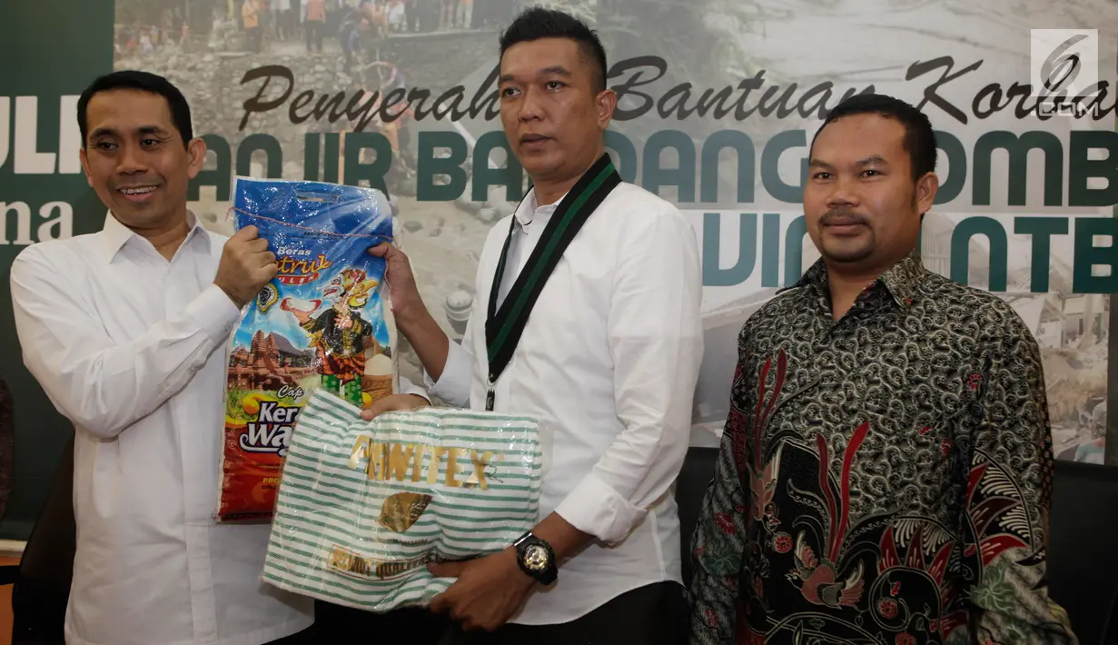 Presidium Majelis Nasional KAHMI, Kamrussamad, secara simbolis menyerahkan bantuan beras kepada Muhammad Ridal dan Ketua MD Lombok Timur NTT, Ahmad Roji untuk korban banjir di Lombok Timur NTT, Jakarta, Selasa (21/11). (Liputan6.com/Pool/KAHMI)