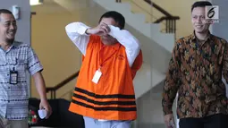 Gubernur Aceh Irwandi Yusuf (tengah) berusaha menutupi wajah usai menjalani pemeriksaan di Gedung KPK, Jakarta, Jumat (6/7). Irwandi diduga menerima suap dana Otonomi Khusus (Otsus) Provinsi Aceh Tahun 2018. (Merdeka.com/Dwi Narwoko)