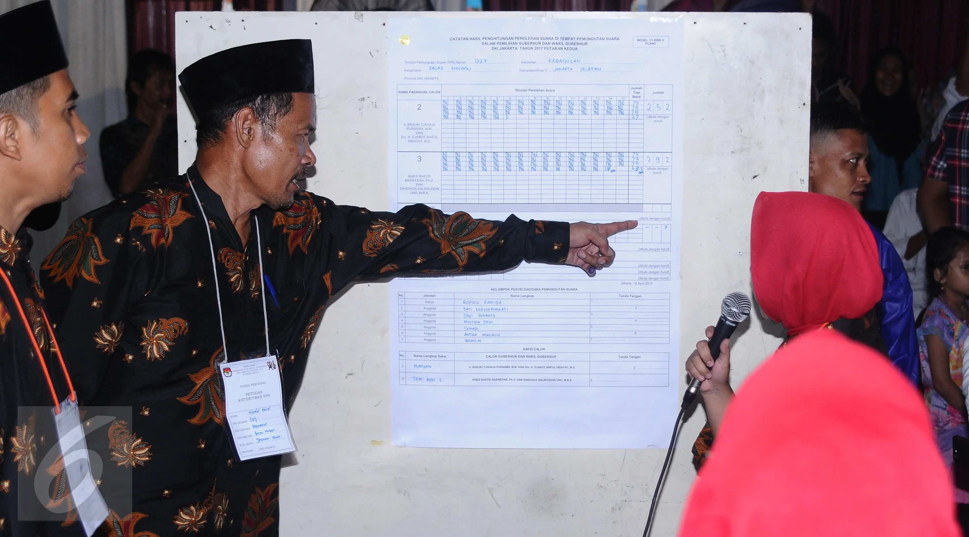 Petugas KPPS menunjuk hasil penghitungan surat suara Pilkada DKI Jakarta putaran 2 di TPS 027, Kebagusan, Jakarta, Rabu (19/4). Pasangan Anis Baswedan-Sandiaga Uno unggul 292-252. (Liputan6.com/Helmi Fithriansyah)