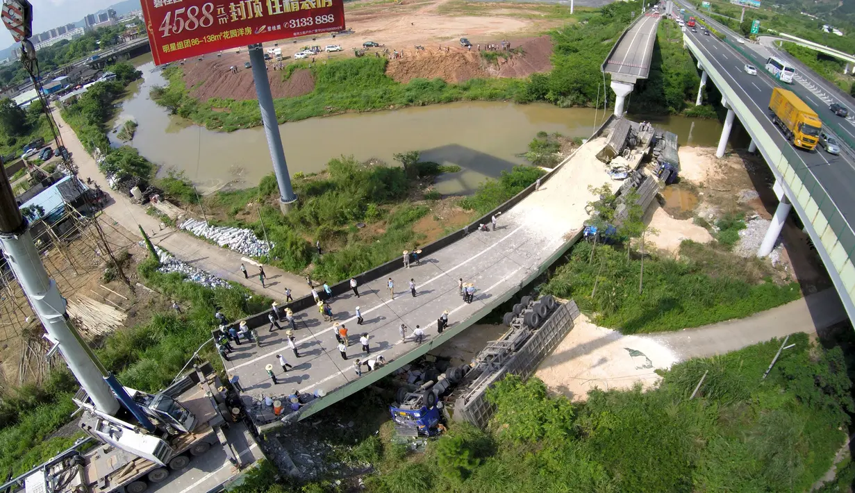 Sejumlah warga melihat kondisi jalan layang yang ambruk dan kendaraan yang terjatuh di Heyuan, Guangdong, China, (19/6/2015). Menurut media setempat, penyebab runtuhnya jalan layang tersebut masih dalam penyelidikan. (REUTERS/Stringer)