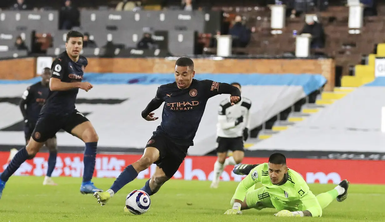 Striker Manchester City, Gabriel Jesus, melewati kiper Fulham, Alphonse Areola, pada laga Liga Inggris di Stadion Craven Cottage, Sabtu (14/3/2021). City menang dengan skor 3-0. (Adam Davy/Pool via AP)