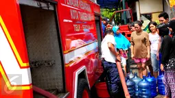 Petugas pemadam kebakaran membantu pembagian air bersih kepada warga di Jalan Kakap Raya, Tanggerang, Senin (17/8/2015). Dalam beberapa hari terakhir, warga Tangerang dan sekitarnya kesulitan mendapatkan air bersih. (Liputan6.com/Faizal R Syam)