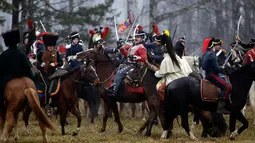 Sejumlah peserta berpakaian seperti tentara Rusia dan Prancis tahun 1812 mengunggang kuda melakukan adegan pertempuran di Belarus (26/11). Acara ini juga untuk memperingati 205 tahun perang Berezina. (AP Photo/Sergei Grits)