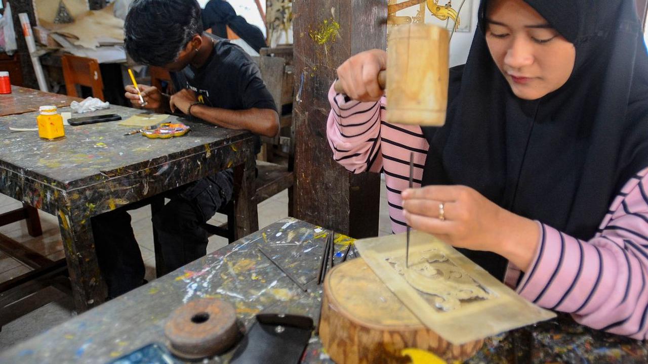 Mahasiswa Politeknik  ATK Yogyakarta belajar membuat wayang kulit di Griya Ukir Kulit (Wayang) Sagio di kawasan Bantul, Yogyakarta, Senin (04/09/2023).<br>