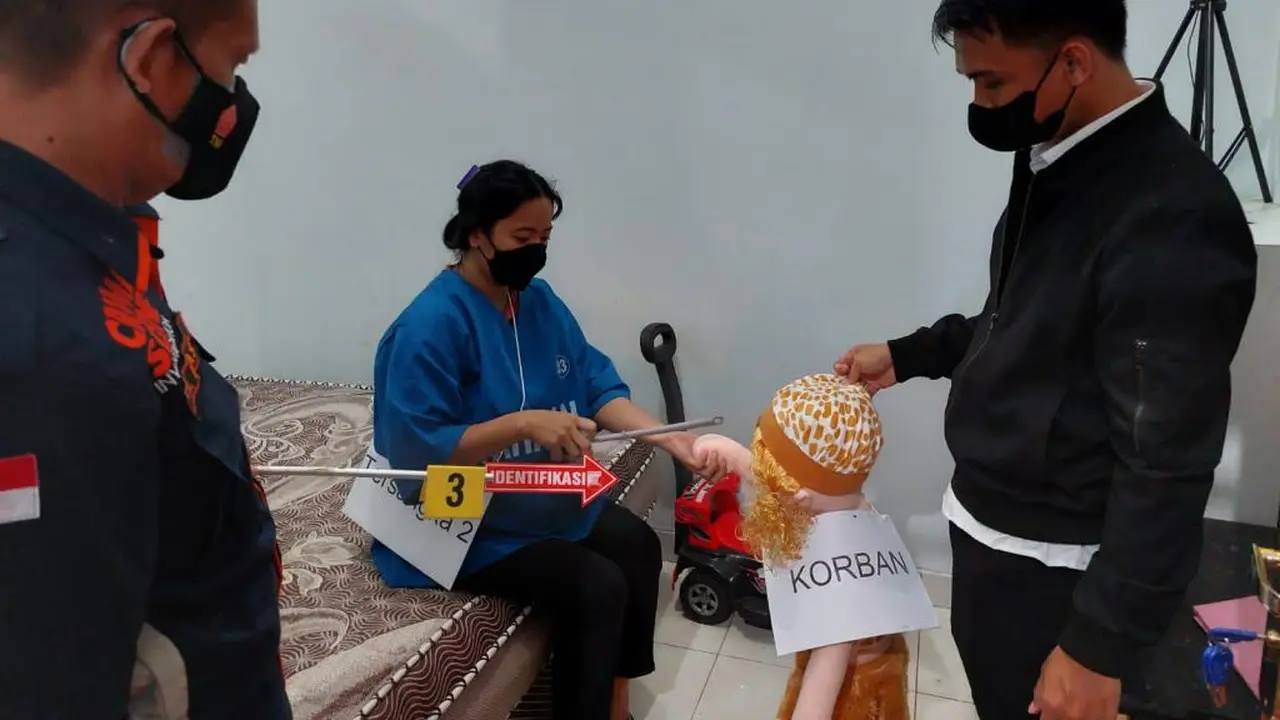 Salah satu tersangka saat memerankan adegan pembunuhan
