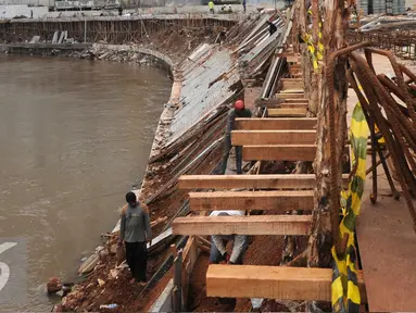 Pekerja menyelesaikan pemasangan turab di kawasan Kampung Melayu, Jakarta, Jumat (27/5) Pemasangan turab tersebut dilakukan untuk menormalisasikan Kali Ciliwung dan mengantisipasi banjir. (Liputan6.com/Helmi Afandi)