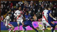 Penyerang Real Madrid, Vinicius Junior (tengah) mencoba menerobos pertahanan Rayo Vallecano pada pertandingan La Liga Spanyol di stadion Vallecas di Madrid, Spanyol, Minggu (27/2/2022). Real Madrid menang tipis atas Rayo Vallecano 1-0. (AP Photo/Jose Breton)