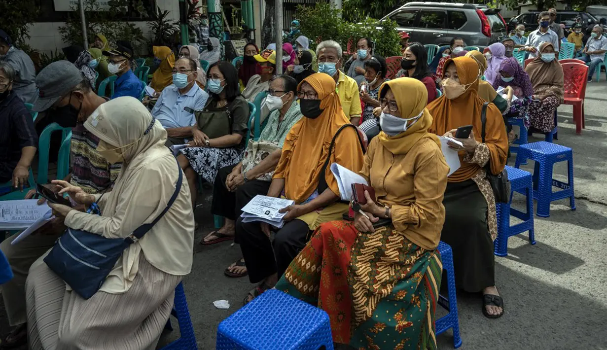 Warga menunggu giliran untuk menerima dosis vaksin booster COVID-19 Pfizer di Surabaya, Jawa Timur, Kamis (13/1/2022). (JUNI KRISWANTO/AFP)