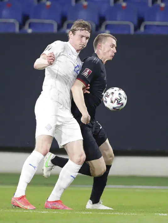 Penyerang Timnas Islandia, Jon Dadi Bodvarsson dan bek Timnas Jerman, Lukas Klostermann berebut bola pada pertandingan kualifikasi Piala Dunia 2022 Zona Eropa Grup J di Duisburg, Jumat (26/3/2021) dinihari WIB. Jerman berhasil melumat Islandia dengan skor 3-0. (AP Photo/Michael Sohn)