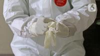 dr Rahmadi Iwan Guntoro, Sp.P memakai sarung tangan bedah karet steril di Rumah Sakit Haji, Jakarta, Kamis (9/4/2020). Standar APD tingkat perlindungan 3 diperuntukkan untuk ruang prosedur dan tindakan operasi pada pasien dengan kecurigaan atau terkonfirmasi COVID-19. (Liputan6.com/Herman Zakharia)