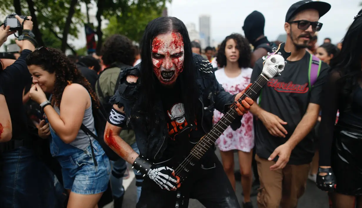 Seorang pria memakai kostum dan dandanan menyerupai zombie dalam acara Zombie Walk di pantai Copacabana, Rio de Janeiro, Brasil, Jumat (2/11). Ribuan orang ini beraksi sebagai Zombie untuk memeriahkan peringatan Hari Para Arwah. (Mauro PIMENTEL/AFP)