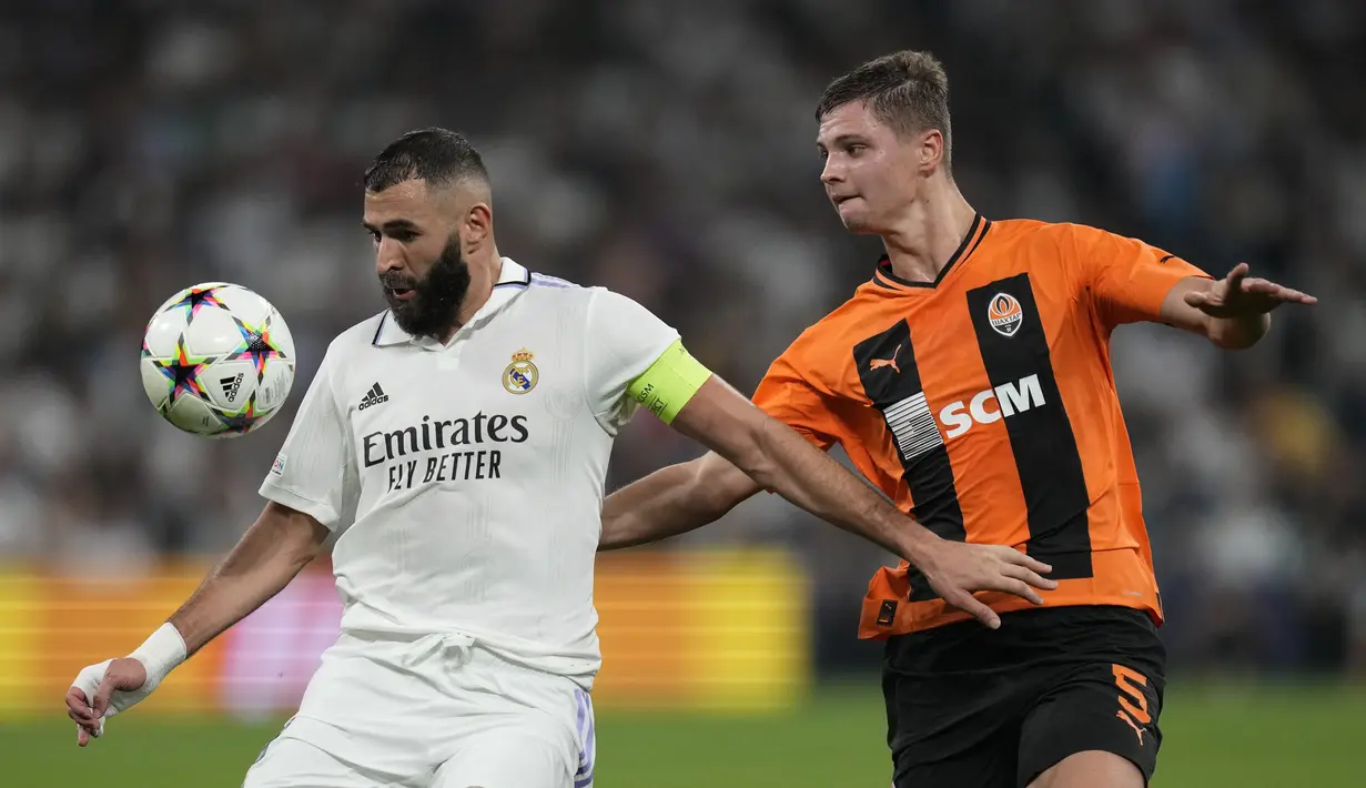 Penyerang Real Madrid Karim Benzema berebut bola dengan bek Shakhtar Donetsk Valeriy Bondar dalam matchday ketiga Grup F Liga Champions 2022/2023 di Santiago Bernabeu, Kamis dini hari WIB (6/10/2022).Tak ada gol tambahan sepanjang babak kedua. Real Madrid keluar sebagai pemenang. (AP Photo/Bernat Armangue)