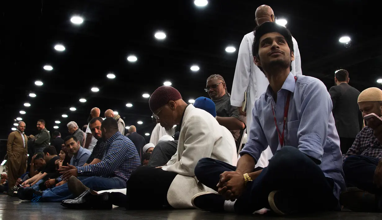 Sejumlah pelayat duduk di lantai ketika menghadiri salat jenazah Muhammad Ali di Freedom Hall, Louisville, Kentucky, Kamis (9/6). Prosesi di Freedom Hall adalah seremonial untuk mengucapkan selamat tinggal terakhir pada sang legenda. (JIM WATSON/AFP)