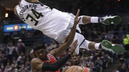 Aksi pemain Milwaukee Bucks,  Giannis Antetokounmpo melakukan dunks  melewati pemain Chicago Bulls pada lanjutan NBA di BMO Harris Bradley Center, (15/12/2016). Bucks menang 108-97.  (AP/Morry Gash)