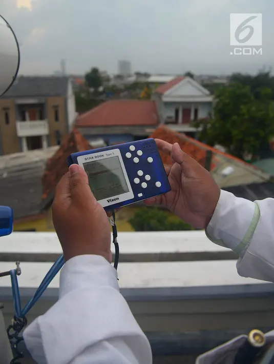 Petugas menunjukkan sebuah alat saat meneropong posisi hilal (bulan) dari Pondok Pesanteren Al-Hidayah Jakarta, Selasa (15/5). (Merdeka.com/Imam Buhori)