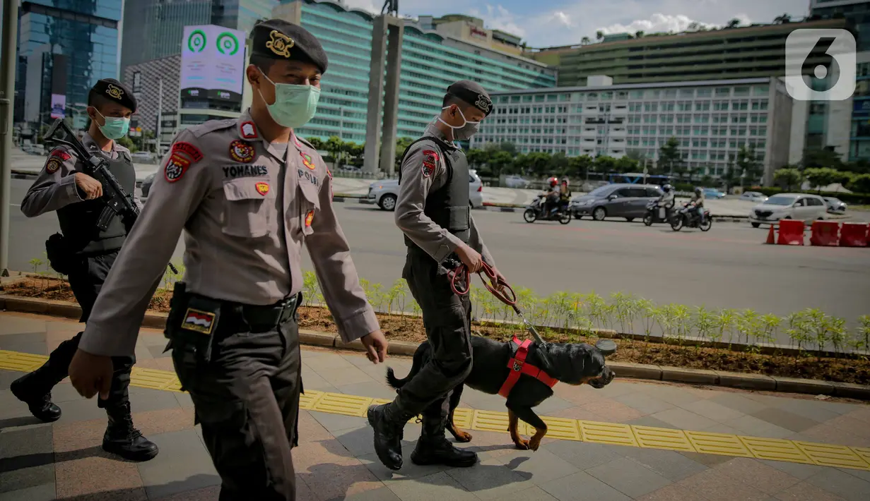 Anggota kepolisian bersama polisi satwa berpatroli keamanan di kawasan Bundaran HI, Jakarta, Rabu (8/4/2020). Gubernur DKI Jakarta Anies Basewedan pun menegaskan patroli keamanan baik oleh Satpol PP, TNI, hingga Polri akan ditingkatkan. (Liputan6.com/Faizal Fanani)