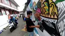 Warga membuat mural saat pelaksanaan kegiatan mural Raincity Strike #8 di Kampung Batik Cibuluh, Bogor, Minggu (22/11/2020). Kegiatan seni mural ini melibatkan puluhan seniman mural se-Jabodetabek di kampung batik. (merdeka.com/Arie Basuki)