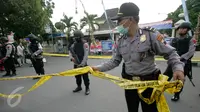 Petugas memasang garis polisi di lokasi bom bunuh diri di Mapolresta Solo, Jawa Tengah, Selasa (5/7). Garis polisi tersebut dipasang mulai dari sisi barat jalan Adi Sucipto menuju sisi timur Jalan KS Tubun. (Liputan6.com/Boy Harjanto)