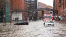 Mobil ditarik keluar dari air banjir oleh pemadam kebakaran setelah badai 'Nadia' menyapu Hamburg, Jerman utara, Minggu (30/1/2022). Sapuan badai telah membuat air sungai Elbe meluap hingga membanjiri pasar ikan di Hamburg. (Daniel Bockwoldt / dpa / AFP)