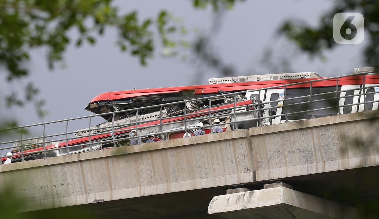 Petugas melakukan persiapan evakuasi kereta LRT yang mengalami kecelakaan beberapa waktu lalu di ruas Cibubur, Jakarta, Jumat (29/10/2021). Pekerjaan evakuasi akan dilaksanakan setiap pukul 22.00-04.00 WIB pada tanggal 29-30 Oktober 2021 dan 1-3 November 2021. (Liputan6.com/Herman Zakharia)