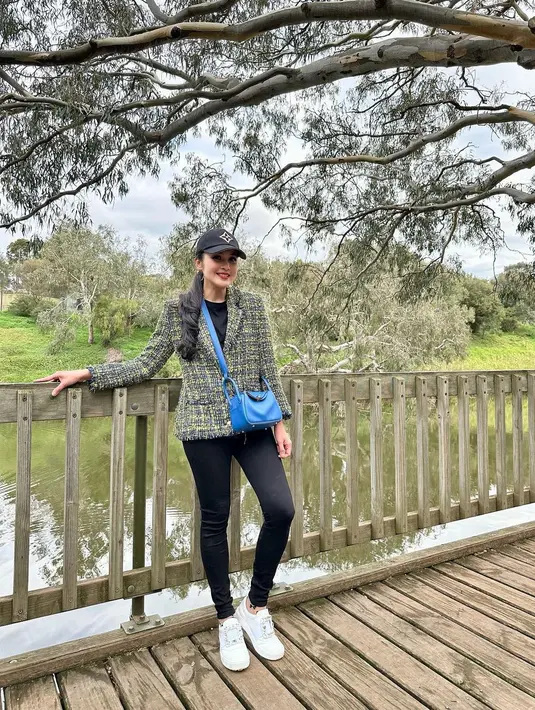 Vibe lady boss saat berlibur ala Sandra Dewi. Ia mengenakan kaus hitam yang dipadunya dengan celana jeans hitam, ditumpuknya dengan tweed blazer bernuansa kehijauan. Ia padukan lagi penampilannya ini dengan topi hitam, sling bag biru, dan sneakers putih. Foto: Instagram.