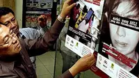 Koordinator Administrasi Timnas Penanggulangan Pelanggaran Hak Kekayaan Intelektual (PPHKI), Ansori Sinungan, memasang poster yang berisikan pentingnya penggunaan software asli, Surabaya.(Antara)