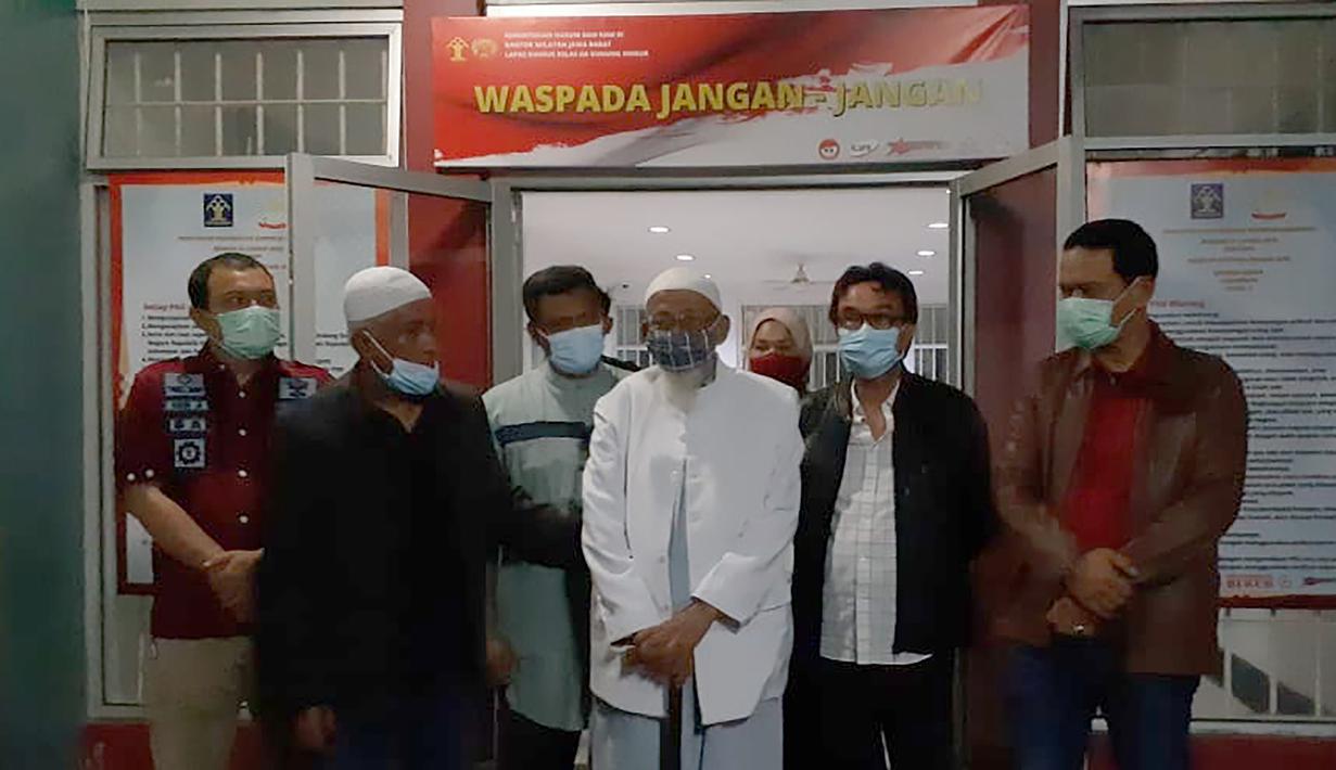 Abu Bakar Baasyir bersama petugas lapas foto bersama setelah dibebaskan dari Lapas Gunung Sindur, Kabupaten Bogor, Jawa Barat, Jumat (8/1/2021). (Handout/Indonesia National Prison/AFP)