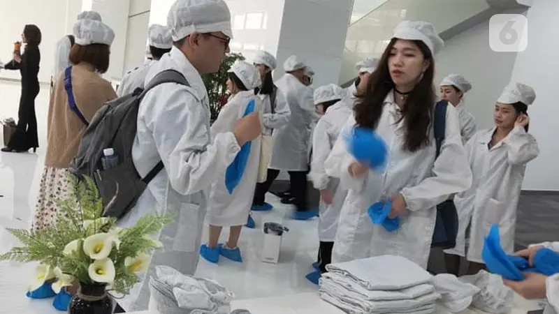 Persiapan memasuki pabrik Oppo di Dongguan, Guangdong, Tiongkok. Pengunjung mengenakan pakaian khusus, topi, dan penutup sepatu. (Liputan6.com/Ramdania El Hida)