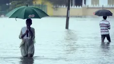Warga menggunakan payung melewati jalanan yang tergenang banjir akibat hujan lebat di Colombo, Senin (16/5). Banjir dan tanah longsor di Sri Lanka menelan sedikitnya delapan korban jiwa, termasuk seorang bayi berusia 10 bulan. (Lakruwan Wanniarachchi/AFP)