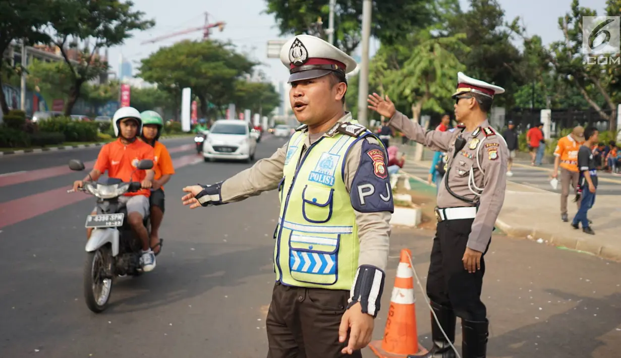 Petugas kepolisian mengatur arus lalu lintas kendaraan di sekitar SUGBK Senayan, Jakarta, Rabu (10/7/2019). Banyaknya kendaraan suporter Persija yang ingin menonton pertandingan membuat sejumlah arus lalu lintas dialihkan untuk mengurai kemacetan. (Liputan6.com/Immanuel Antonius)