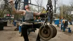 Seorang pria berlatih mengangkat beban di outdoor gym atau pusat kebugaran terbuka di tepi Sungai Dnipro, Kiev, Ukraina, Kamis (18/4). Pusat kebugaran terbuka ini terbilang unik karena memanfaatkan besi tua sebagai alat fitness. (AP Photo/Efrem Lukatsky)