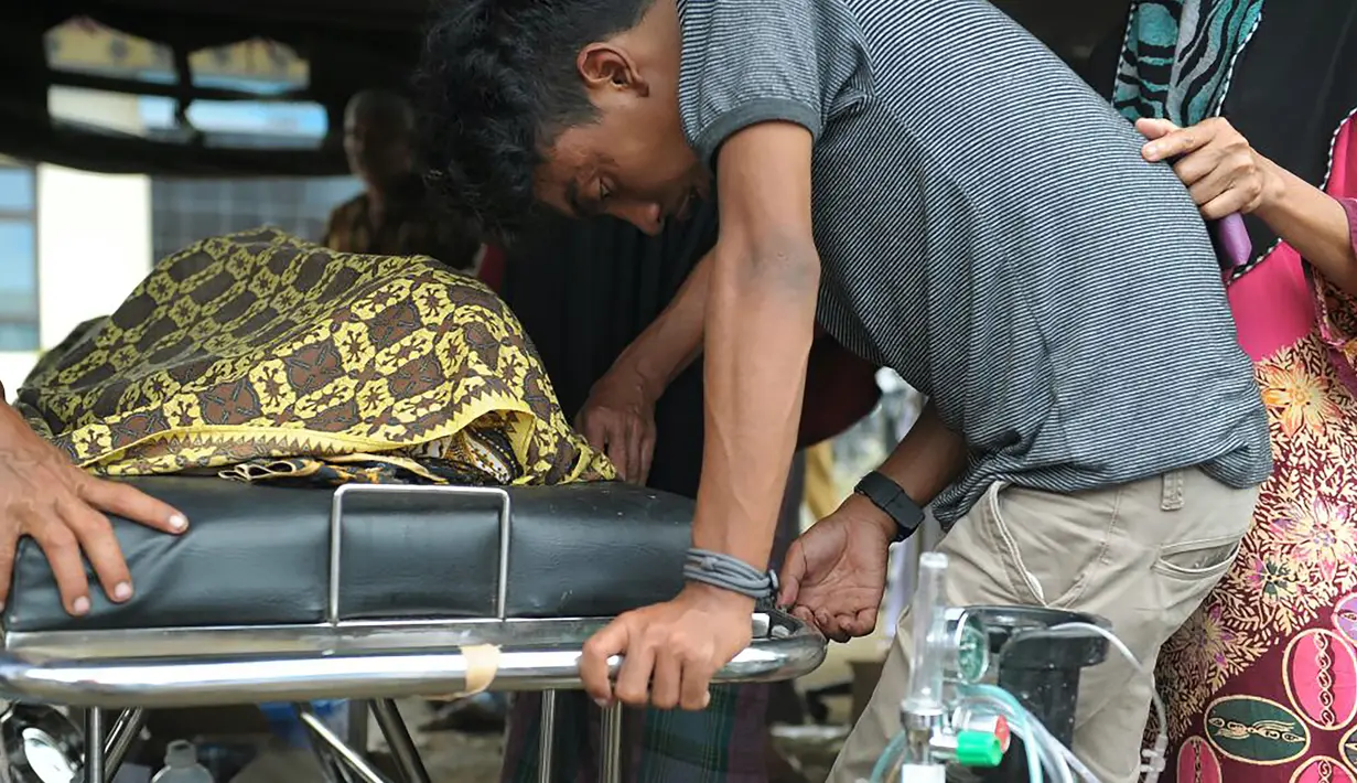 Seorang pria menangis usai kerabatnya meninggal setelah gempa bumi di Pidie Jaya, Aceh, Rabu (7/12). Menurut pejabat setempat, setidaknya 52 orang tewas dan ratusan terluka setelah gempa kuat melanda provinsi Aceh tersebut. (AFP PHOTO/Chaideer Mahyuddin)