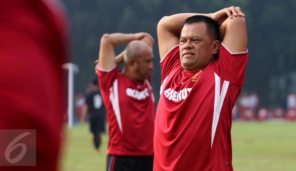 Panglima TNI Jenderal TNI Gatot Nurmantyo melakukan pemanasan sebelum mengikuti pertandingan eksebisi antara tim Eksekutif TNI vs PS Pemred di lapangan Mabes TNI Cilangkap, Jakarta, Jumat (21/10). (Liputan6.com/Risa Rahayu Kosasih)
