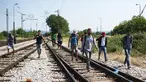 Sejumlah imigran berjalan menyusuri rel kereta api saat perjalanan menuju Gevgelija, wilayah perbatasan Macedonia-Yunani, Kamis (9/7/2015). Mereka menempuh ribuan kilometer agar dapat mengejar kereta api tujuan Serbia. (AFP PHOTO/Robert ATANASOVSKI)