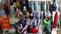 Calon pembeli memilih baju di Pasar Tanah Abang, Jakarta, Sabtu (23/4/2022). Menjelang Lebaran, Pasar Tanah Abang dipadati pengunjung yang memburu busana atau pakaian muslim untuk menyambut Hari Raya Idul Fitri 1443 Hijriah. (Liputan6.com/Herman Zakharia)