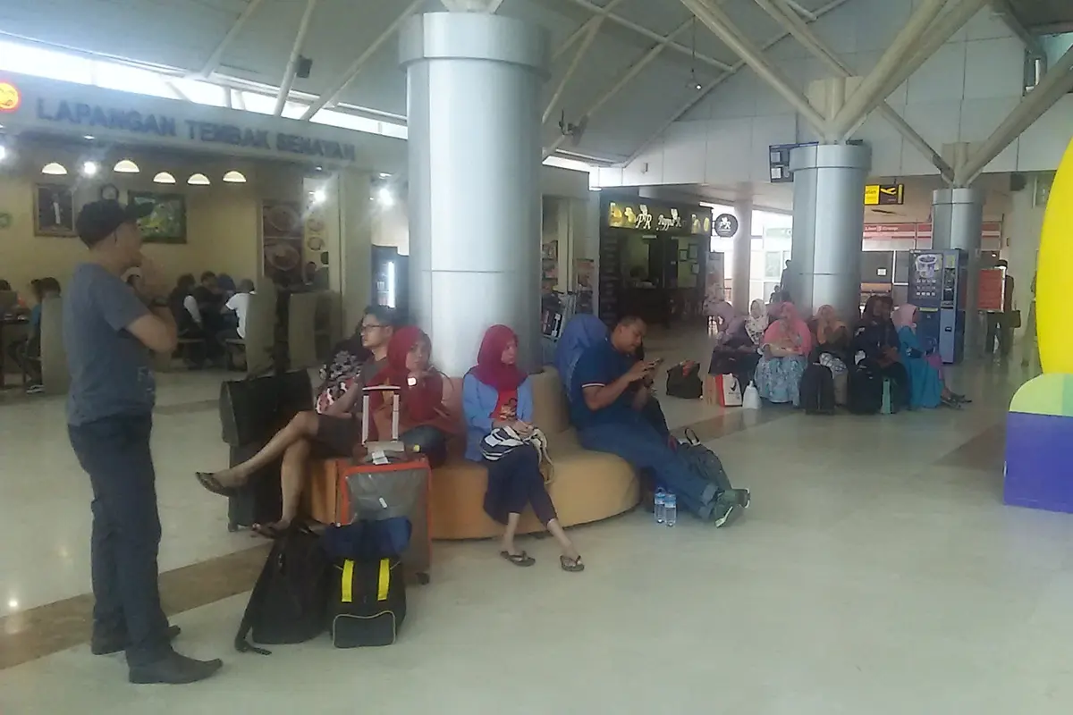 Penumpang di Bandara Internasional Lombok menunggu penerbangan yang dibatalkan akibat erupsi Gunung Agung.