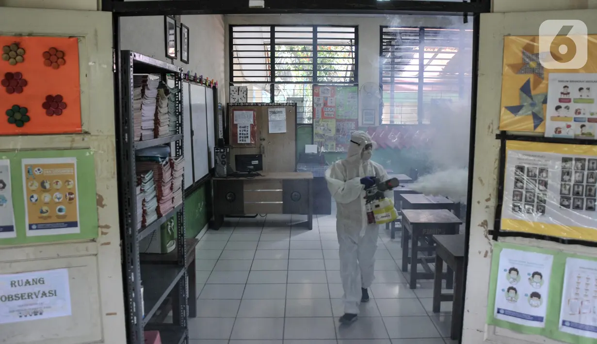 Petugas PMI menyemprotkan disinfektan sebagai upaya pencegahan COVID-19 di SDN Petojo Utara 01, Kecamatan Gambir, Jakarta, Kamis (3/2/2022). Pelaksanaan PTM 100 persen menjadi 50 persen berdasarkan SKB 4 Menteri seiring melonjaknya kasus COVID-19 di lingkungan sekolah. (merdeka.com/Iqbal S. Nugroho)